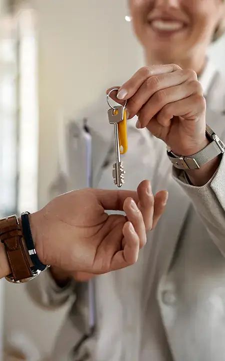 Agente inmobiliaria dando llaves de nueva vivienda
